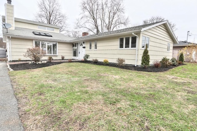 view of front of house with a chimney and a front yard