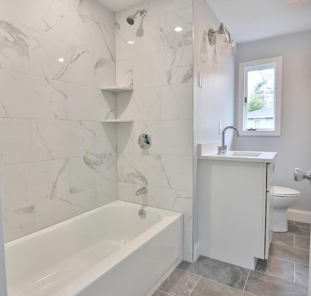 full bathroom with toilet, vanity, washtub / shower combination, baseboards, and tile patterned floors