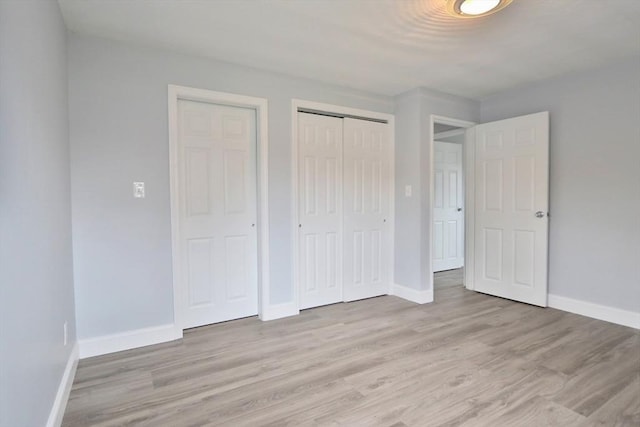 unfurnished bedroom with baseboards and light wood-style floors