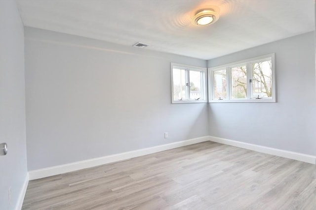 unfurnished room with light wood-style flooring and baseboards