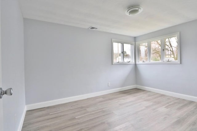 empty room with light wood-type flooring and baseboards