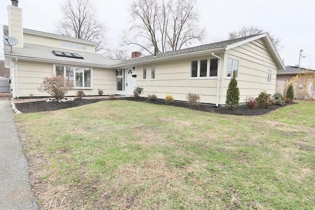 view of front of property with a chimney and a front yard