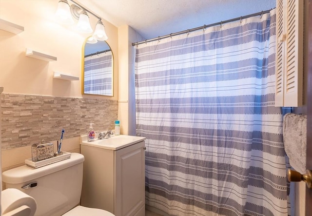 bathroom featuring vanity, tile walls, and toilet