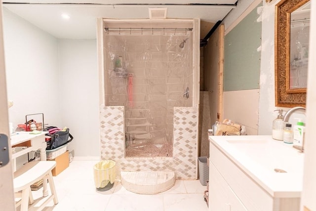 bathroom with tiled shower and vanity