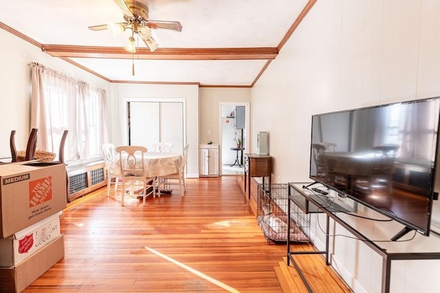 dining space featuring wood-type flooring, ornamental molding, radiator heating unit, beamed ceiling, and ceiling fan