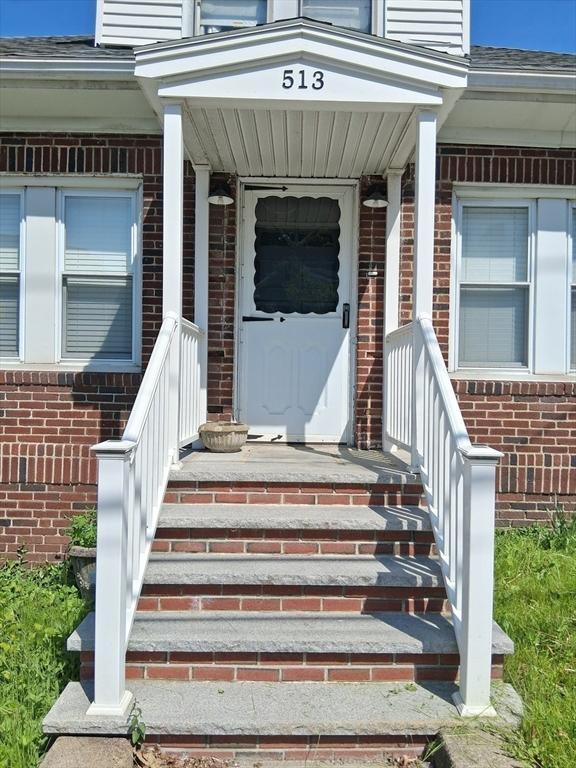 513 Washington Ave, Chelsea, MA 02150 - doorway to property with brick siding, a shingled roof, and covered porch