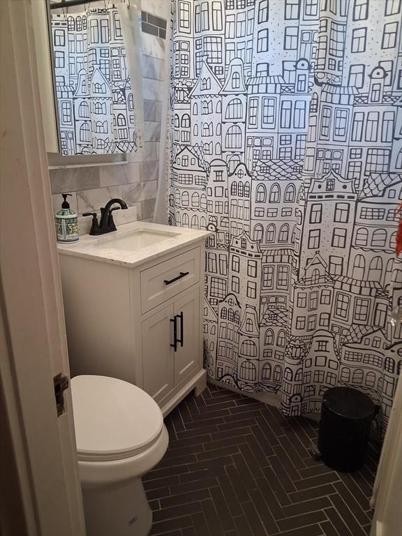 513 Washington Ave, Chelsea, MA 02150 - bathroom with toilet, brick floors, vanity, decorative backsplash, and tile walls