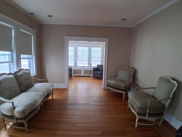 513 Washington Ave, Chelsea, MA 02150 - living area featuring radiator, plenty of natural light, crown molding, wood finished floors, and baseboards