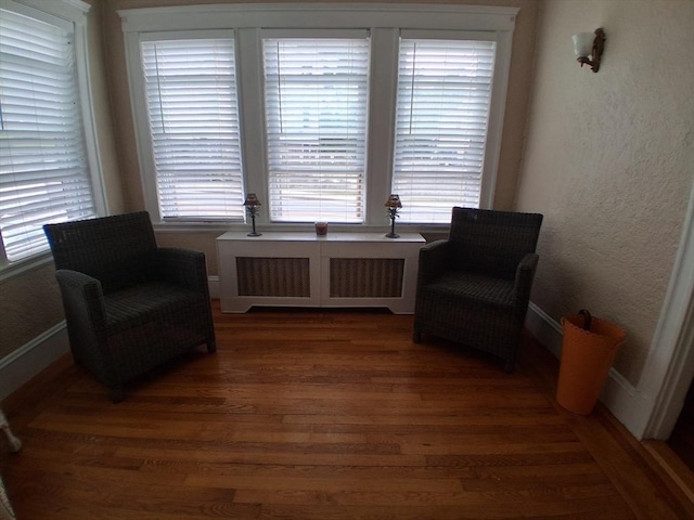 513 Washington Ave, Chelsea, MA 02150 - living area with wood finished floors, radiator, and baseboards