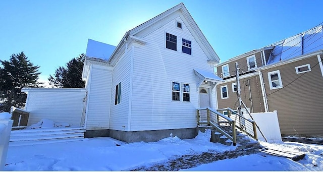 view of snow covered back of property