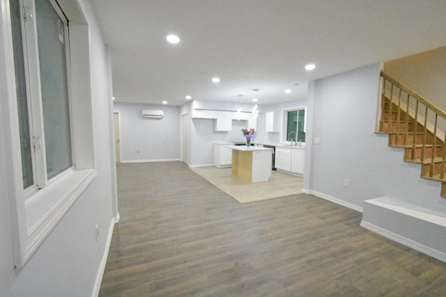 interior space with sink, hardwood / wood-style flooring, and a wall unit AC