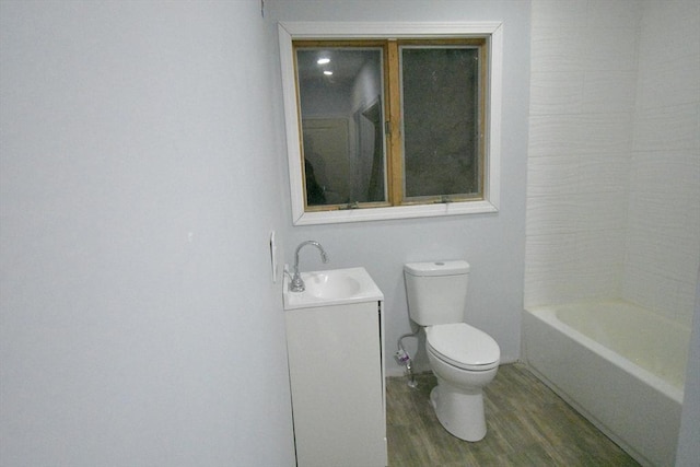 full bathroom featuring hardwood / wood-style flooring, vanity, toilet, and shower / washtub combination