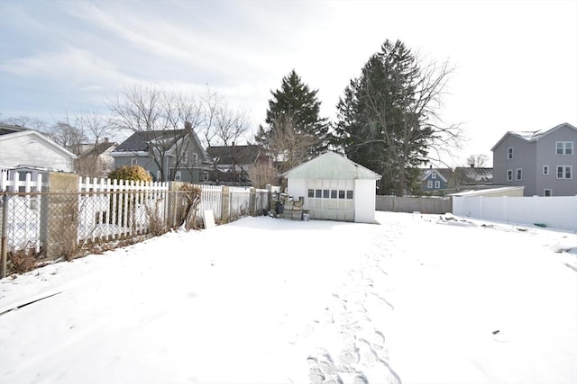 snowy yard with an outbuilding and a garage