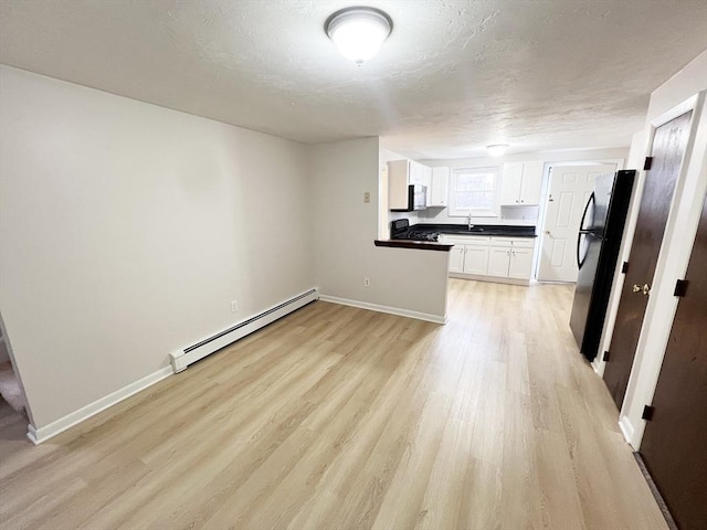 5-7 Monk St, Stoughton, MA 02072 - unfurnished living room with a baseboard radiator and light wood-type flooring