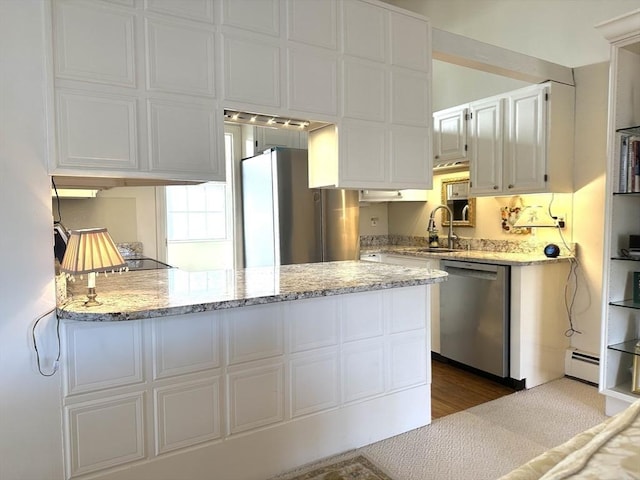 kitchen featuring stainless steel appliances, baseboard heating, light stone counters, kitchen peninsula, and white cabinets