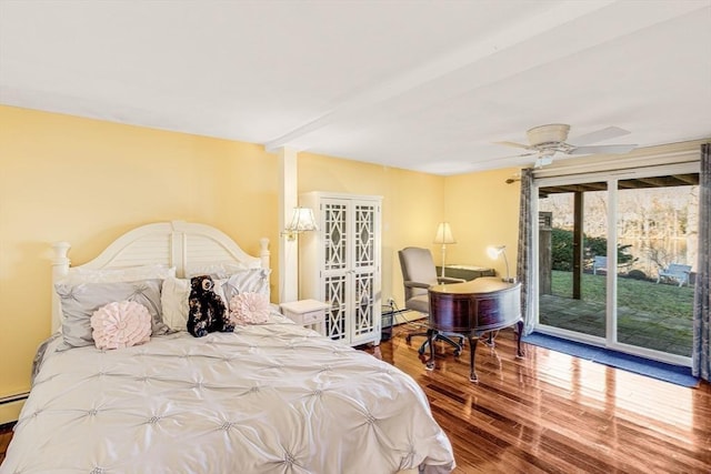 bedroom with access to exterior, ceiling fan, beamed ceiling, a baseboard heating unit, and hardwood / wood-style flooring