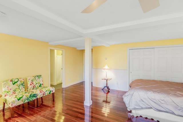 bedroom featuring hardwood / wood-style floors, beam ceiling, a closet, and ceiling fan