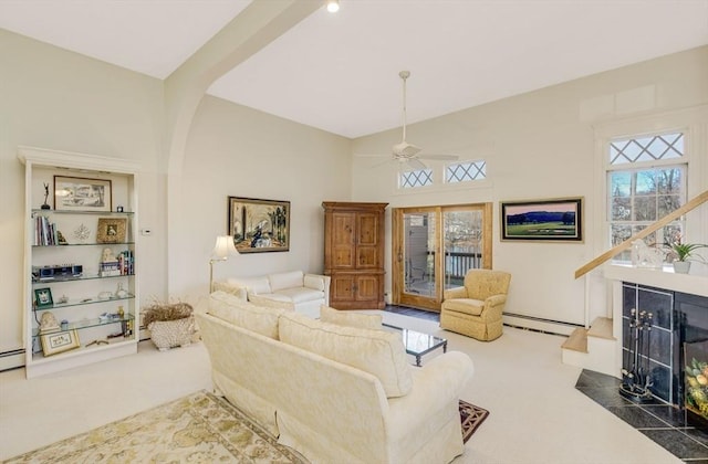 carpeted living room with a premium fireplace, ceiling fan, and a baseboard radiator