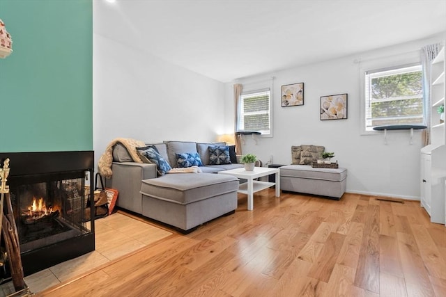 29 1st St Unit C, Salem, MA 01970 - living area featuring a multi sided fireplace, light wood finished floors, and healthy amount of natural light
