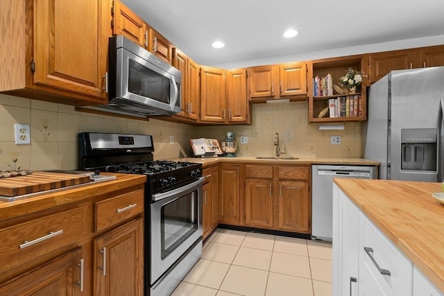 29 1st St Unit C, Salem, MA 01970 - kitchen featuring appliances with stainless steel finishes, wooden counters, light tile patterned flooring, decorative backsplash, and recessed lighting