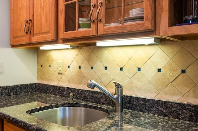8 Franklin St Unit 18, Marblehead, MA 01945 - detailed view of a sink, dark stone counters, glass insert cabinets, and tasteful backsplash