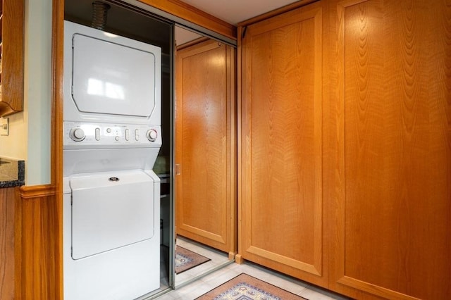 8 Franklin St Unit 18, Marblehead, MA 01945 - laundry room featuring stacked washer / dryer and light tile patterned floors