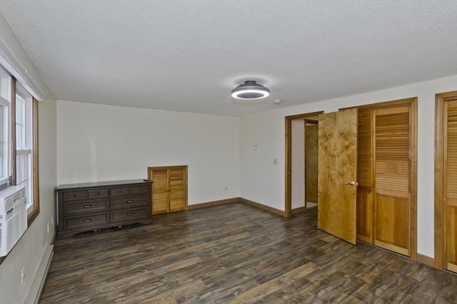 8 Field St, Southwick, MA 01077 - unfurnished bedroom featuring dark wood-style flooring, a textured ceiling, baseboards, and two closets