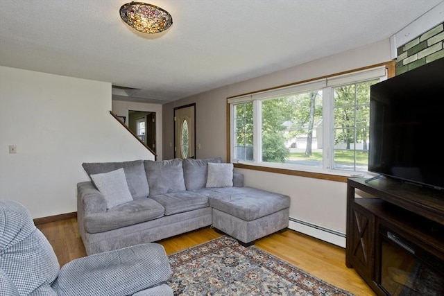 8 Field St, Southwick, MA 01077 - living area with a baseboard radiator, light wood-style flooring, and baseboards