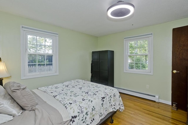 8 Field St, Southwick, MA 01077 - bedroom with a baseboard heating unit, multiple windows, wood finished floors, and baseboards