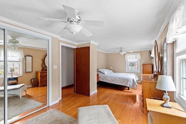 bedroom featuring a textured ceiling, ornamental molding, a closet, and wood finished floors