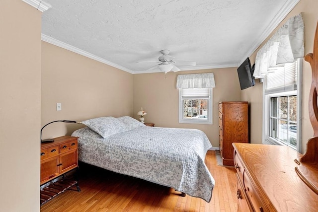 bedroom with light wood-style floors, ornamental molding, and a textured ceiling