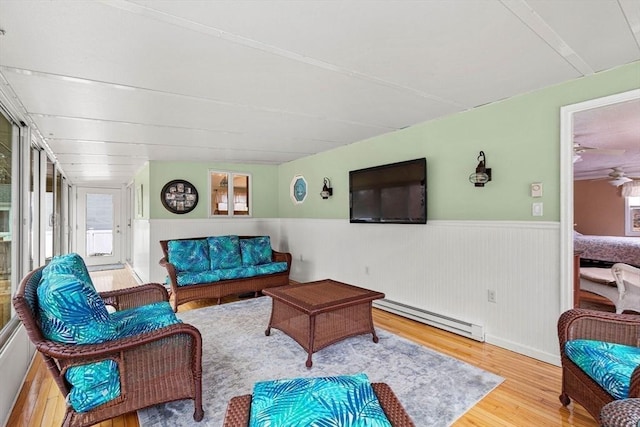 living room with wainscoting, baseboard heating, and wood finished floors