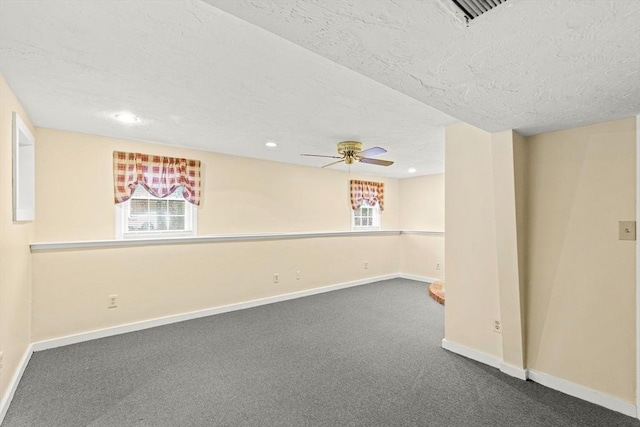 basement featuring recessed lighting, dark carpet, a textured ceiling, and baseboards