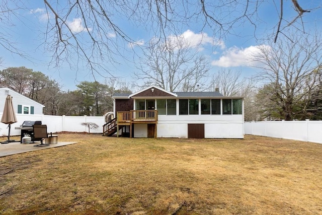 rear view of property with a chimney, a lawn, stairway, a sunroom, and a fenced backyard