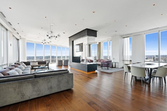 living room with floor to ceiling windows, plenty of natural light, a chandelier, and dark hardwood / wood-style floors