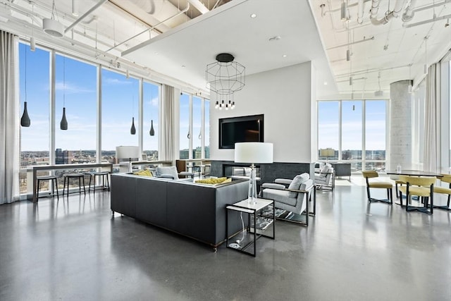 living room featuring a healthy amount of sunlight, a wall of windows, and concrete flooring