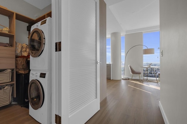 washroom featuring hardwood / wood-style floors and stacked washing maching and dryer