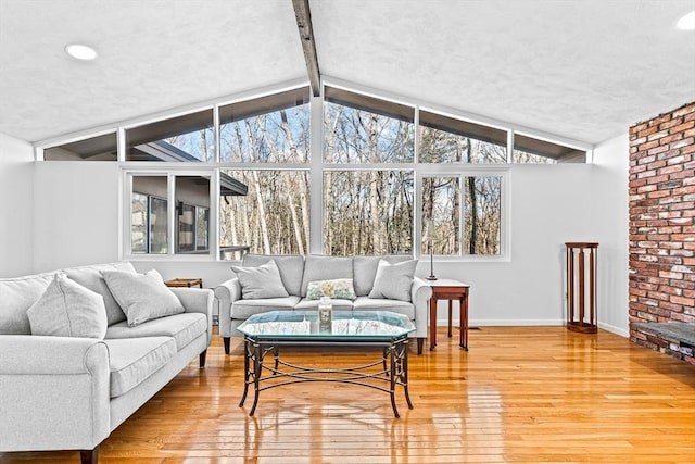 sunroom featuring lofted ceiling with beams