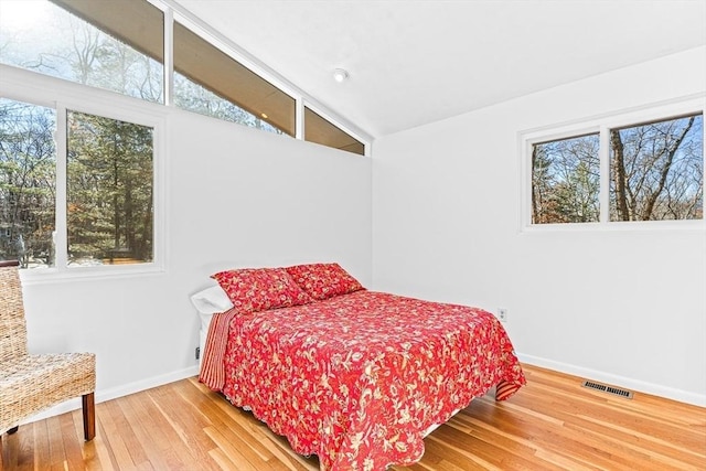 bedroom with lofted ceiling and hardwood / wood-style floors