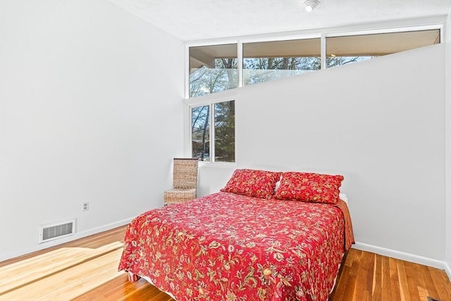 bedroom with lofted ceiling and hardwood / wood-style floors