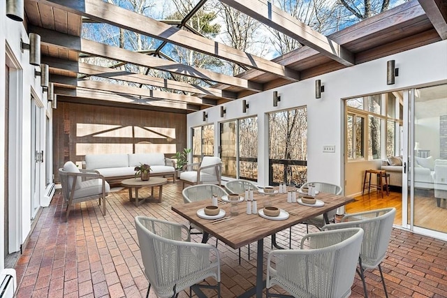 sunroom / solarium featuring a baseboard heating unit and beam ceiling