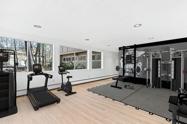 workout area featuring a baseboard radiator and light wood-type flooring