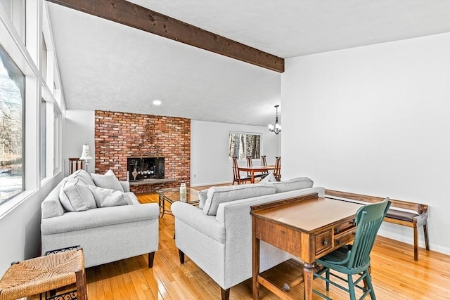 living room with a chandelier, hardwood / wood-style floors, a brick fireplace, and vaulted ceiling with beams