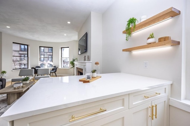 kitchen featuring recessed lighting, a fireplace, light countertops, and open shelves
