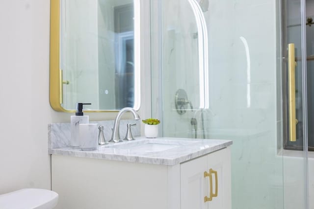 full bath featuring toilet, vanity, and a stall shower