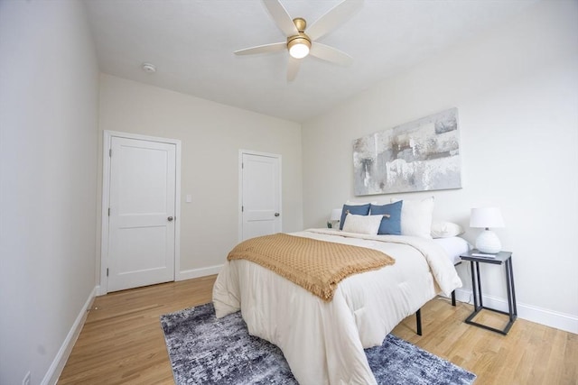 bedroom featuring light wood-style flooring, ceiling fan, and baseboards