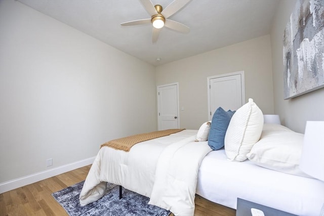 bedroom with ceiling fan, baseboards, and wood finished floors