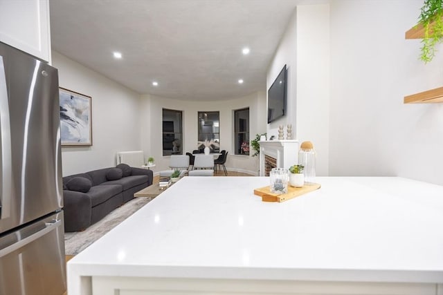 kitchen with open floor plan, light countertops, freestanding refrigerator, and recessed lighting
