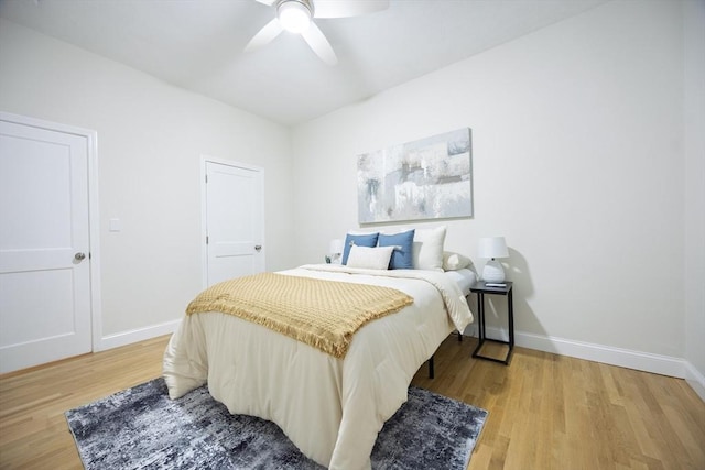 bedroom featuring light wood-type flooring, baseboards, and ceiling fan