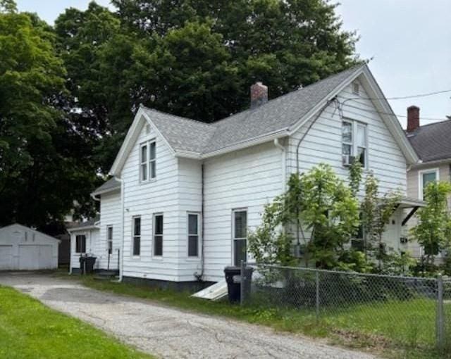 1098 Pleasant St, Palmer, MA 01069 - view of property exterior featuring a chimney, an outdoor structure, and roof with shingles